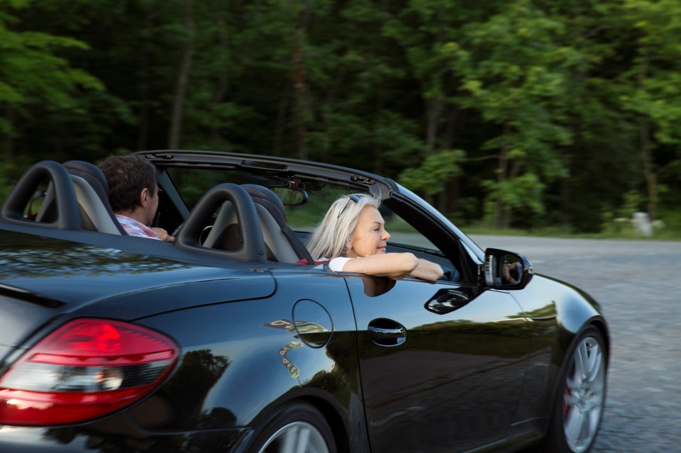 Mature couple in a convertible car.