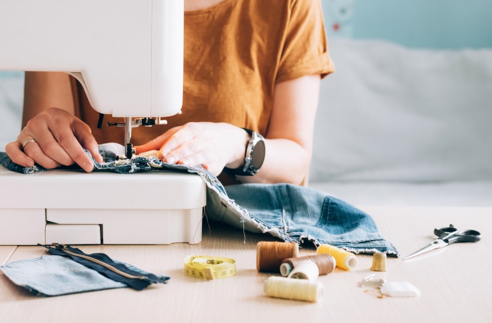 Woman sewing denim on a sewing machine.