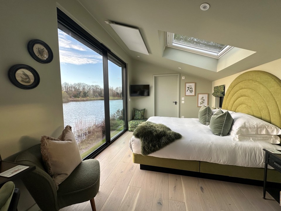 a bedroom with a large bed and a view of a lake