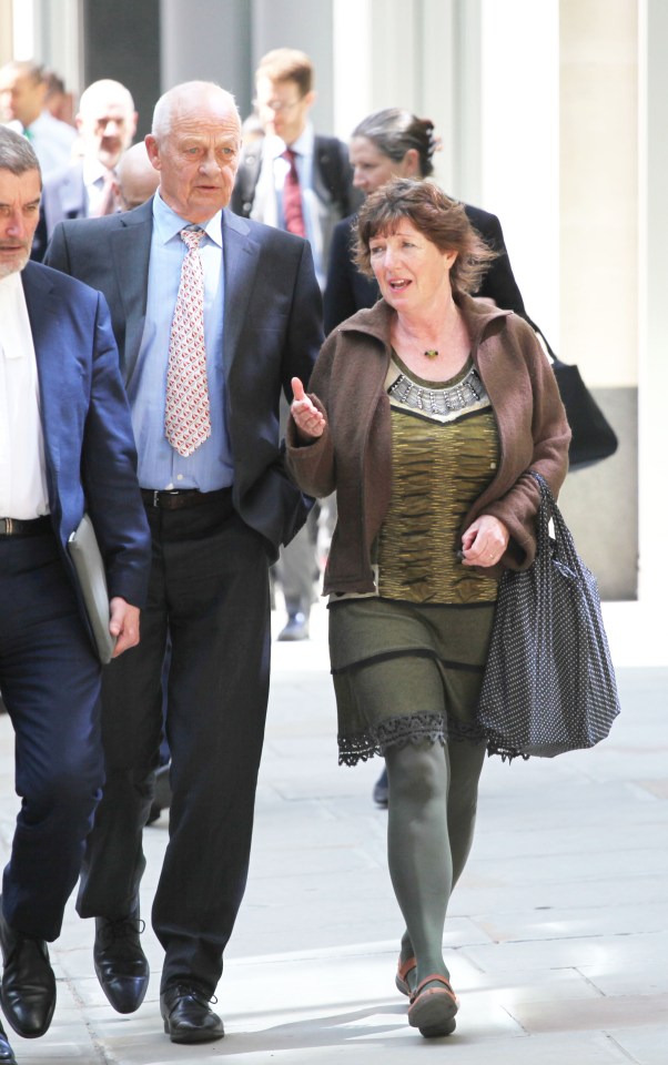 Two people walking outside London's High Court.