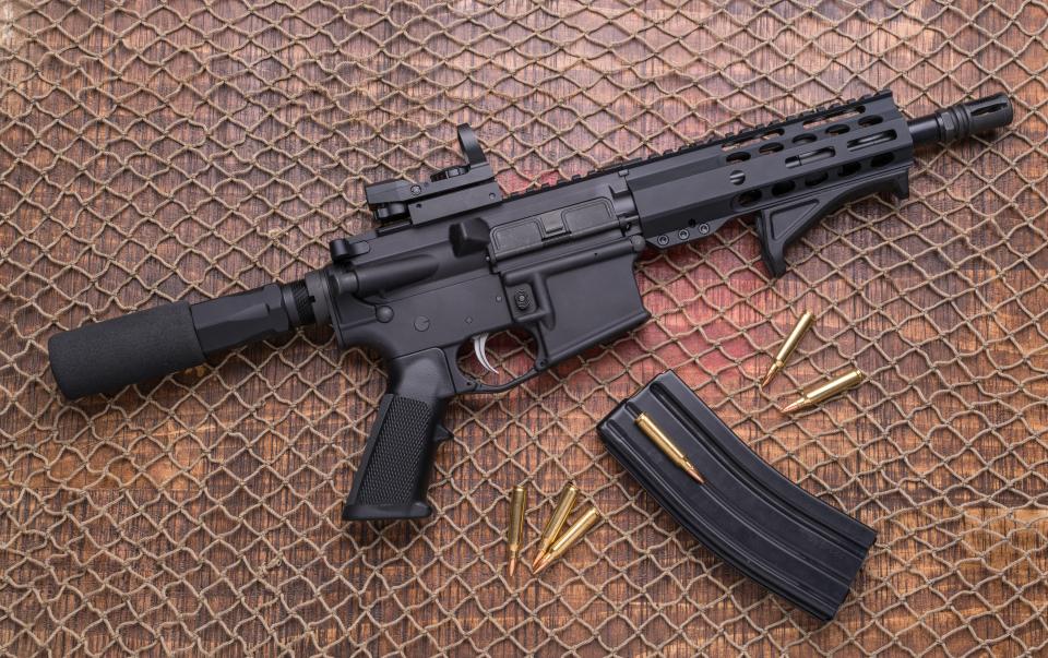 Distressed AR-15 pistol with magazine and ammunition.