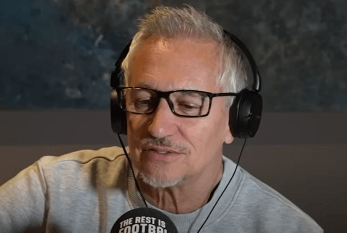 Man wearing glasses and headphones speaks into a microphone.