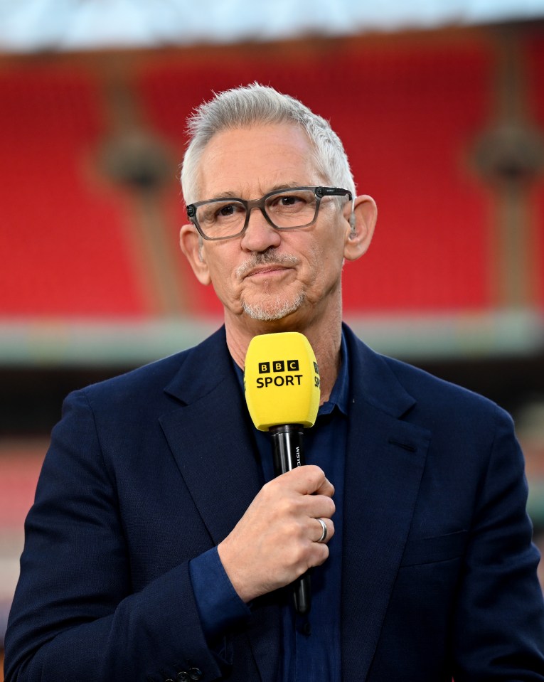 Gary Lineker presenting at a sporting event, holding a BBC Sport microphone.
