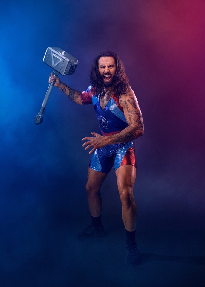 A muscular man with long hair and tattoos wielding a large hammer.