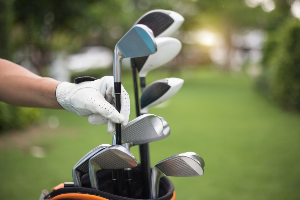 Golf clubs drivers over green field background