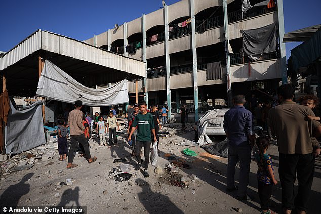 Palestinians inspect the area following an Israeli airstrike at dawn on the Fahmi al-Jarjawi School in the al-Daraj neighborhood of Gaza City