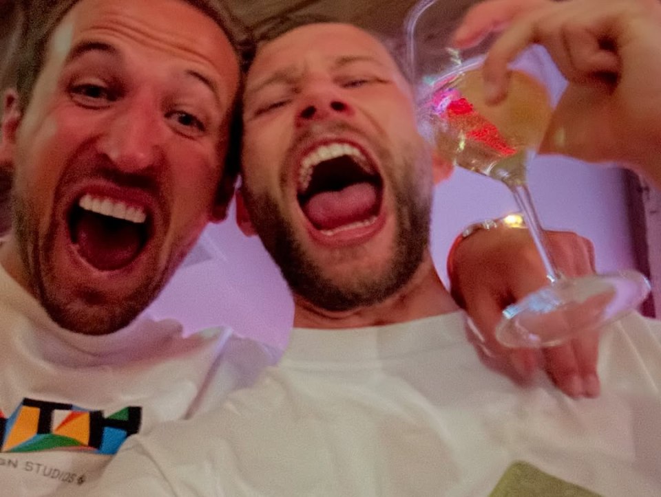 Two men celebrating, one holding a glass of champagne.