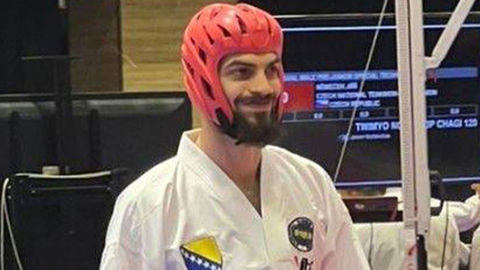 Karate athlete wearing a red head protector.