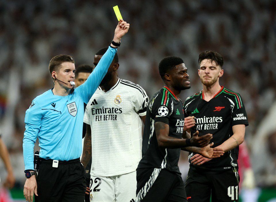 Referee showing Arsenal's Thomas Partey a yellow card.