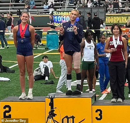 Hernandez (middle) is seen holding up the number one and a medal after winning