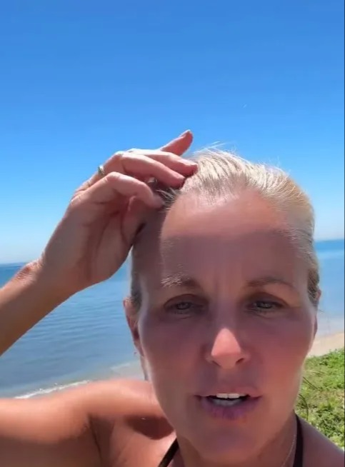 Woman speaking to camera by the ocean.