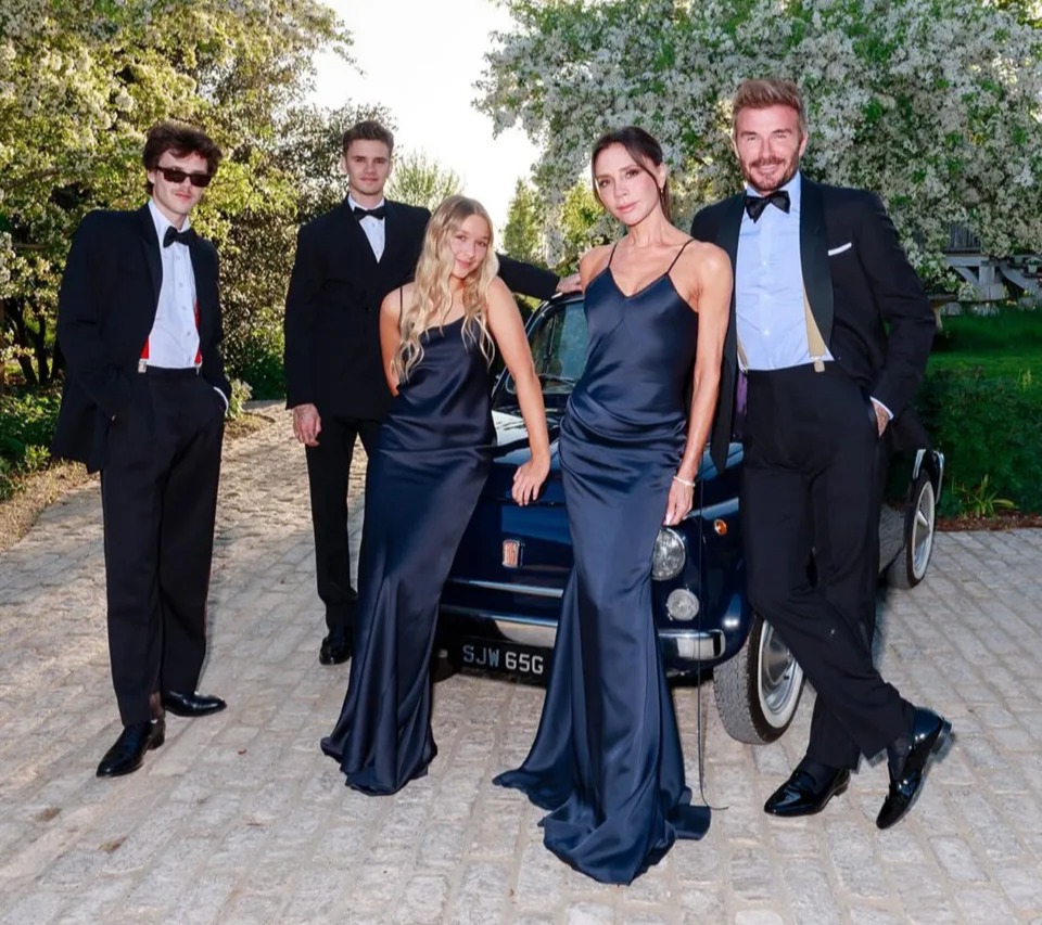 Family posing by a vintage car.