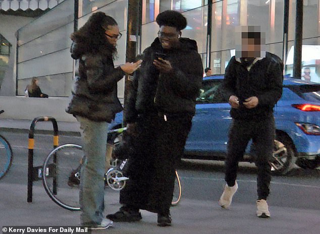 This is the moment a man walked up to an unlocked bike in Central London before stealing it nd riding off unchallenged (Pictured: Two bystanders and the thief)