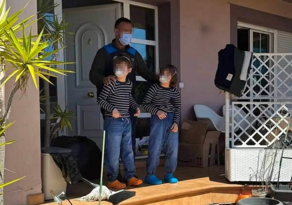 Police officer with two children outside a house.