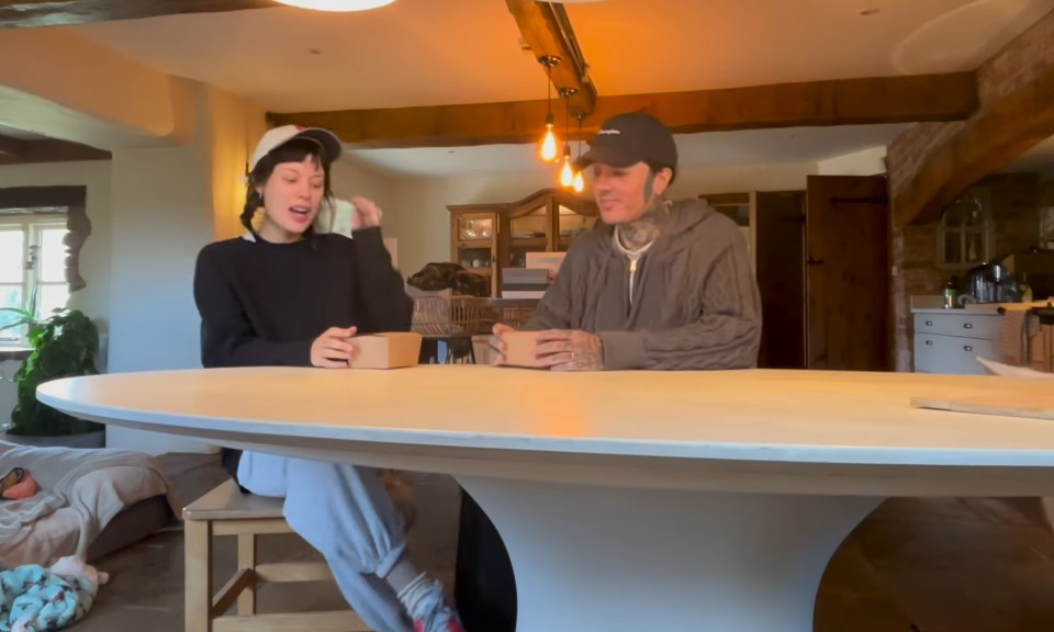 Couple sitting at a table opening small boxes.