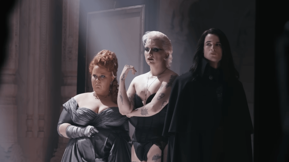 three women are standing next to each other and one has a tattoo on her arm