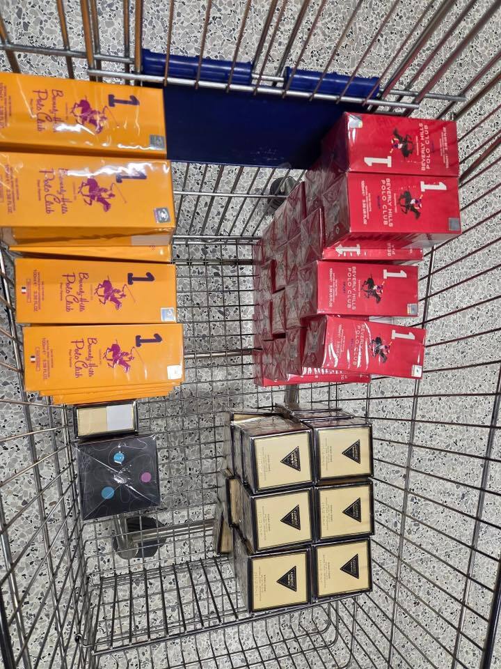 Shopping cart filled with boxes of Beverly Hills Polo Club perfume.