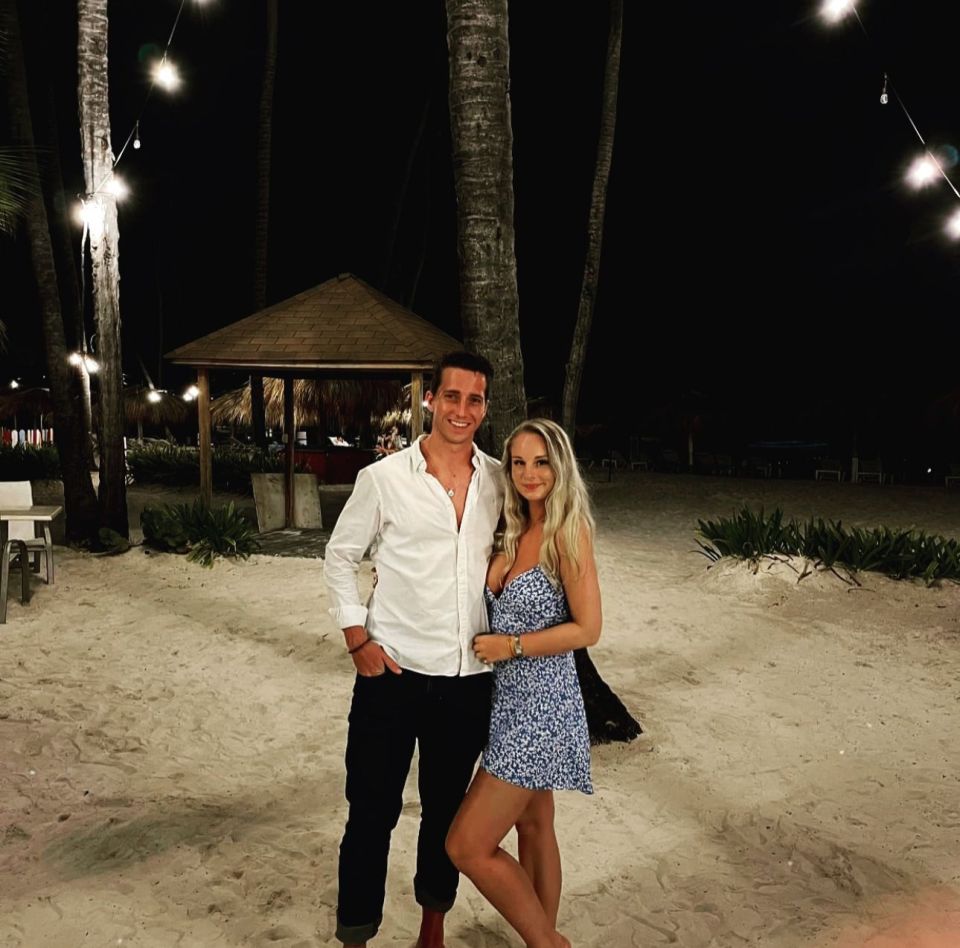 Couple standing on a beach at night.