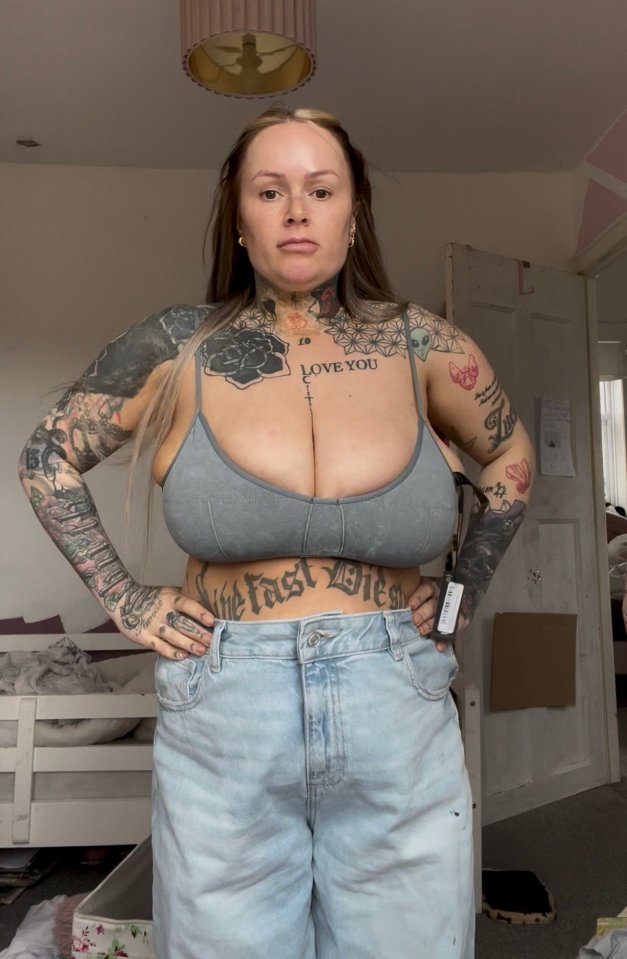 Woman with extensive tattoos showing off her chest after breast reduction surgery.