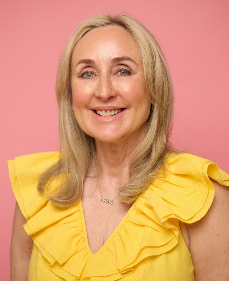 Portrait of a smiling woman wearing a yellow dress.