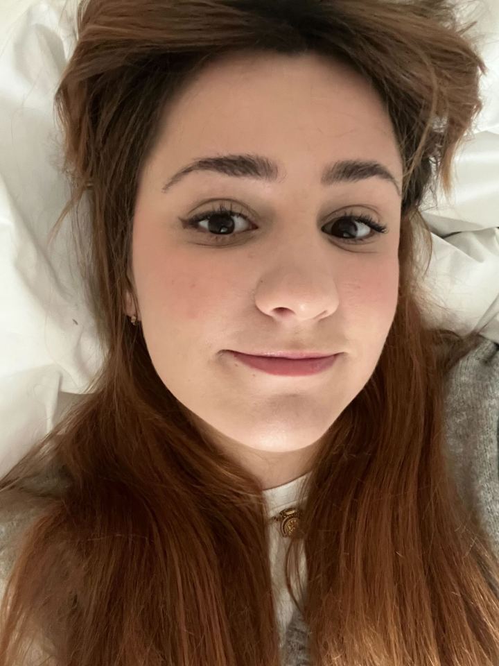 Close-up selfie of a young woman with long brown hair.