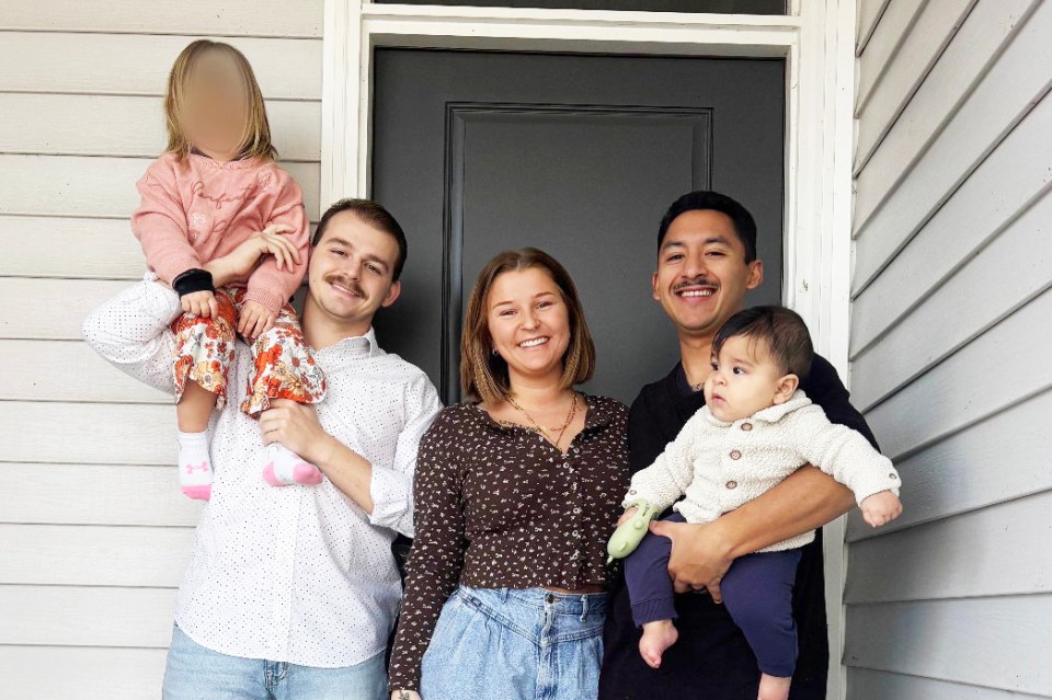 A woman with her ex-husband and current husband, and their two children.