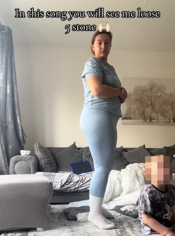 Woman in light blue leggings shows her weight loss.