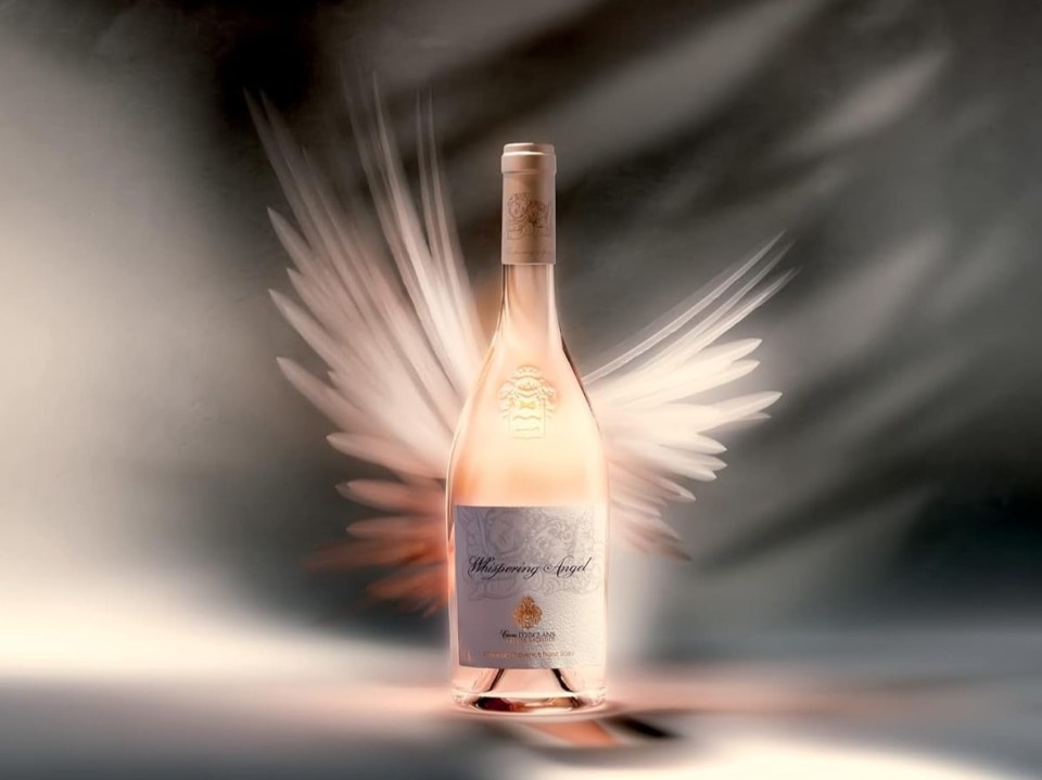Bottle of Whispering Angel rose wine with blurred wings behind it.