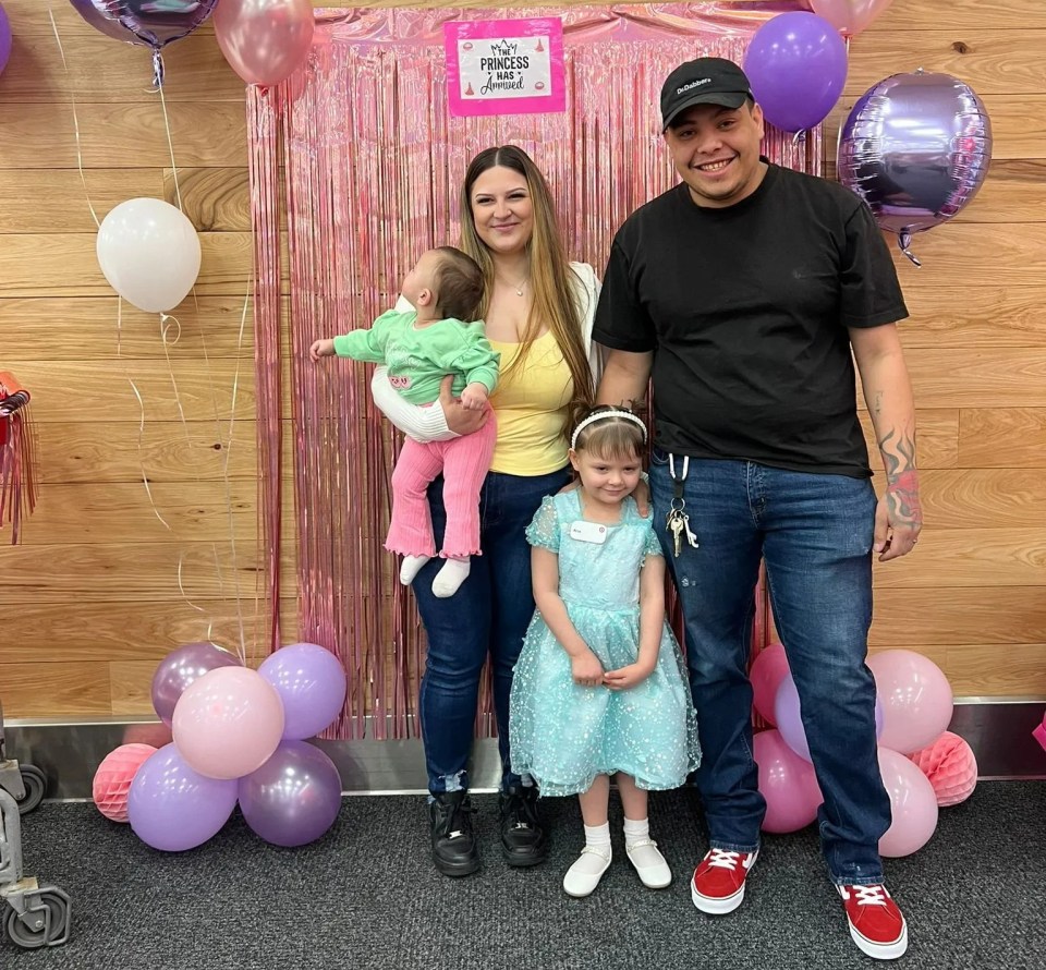 Family portrait in front of a balloon arch.