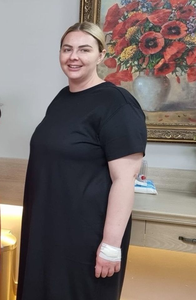 Woman in black dress with bandage on wrist.