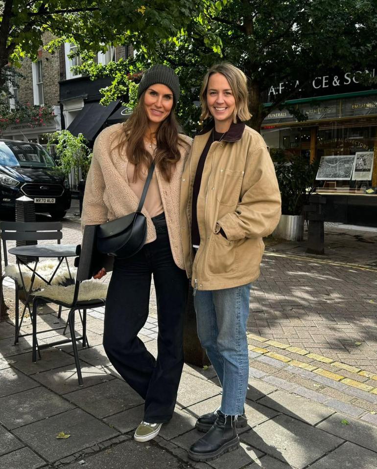 two women are posing for a picture in front of a store called a.f. ce & sons