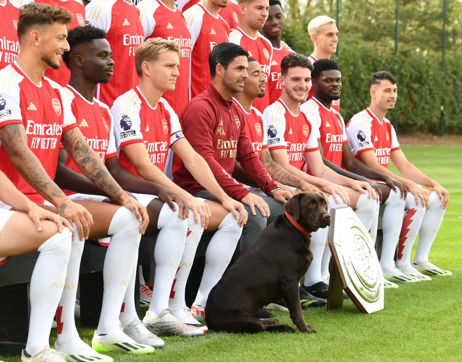 Arsenal soccer team photo with their dog and trophy.
