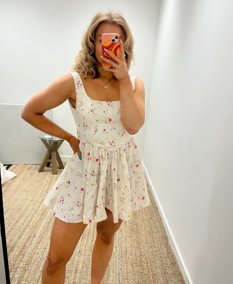 Woman in floral dress holding phone.