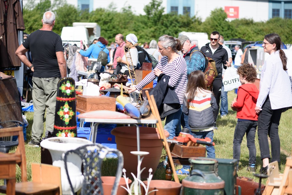 People browsing and shopping at a car boot sale.