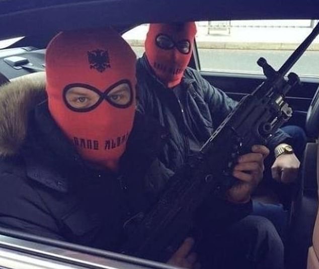 Albanian gang member posts a picture of two members wearing red balaclavas emblazoned with the Albanian flag, while one brandishes a machine gun