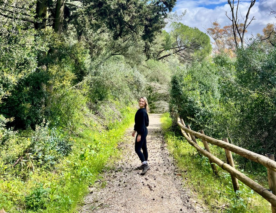 Woman hiking on a trail through a forest.