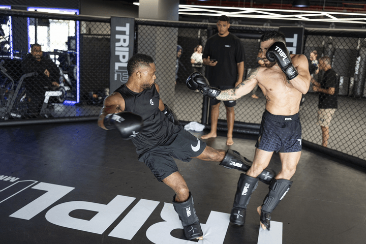 Two men sparring in a gym.