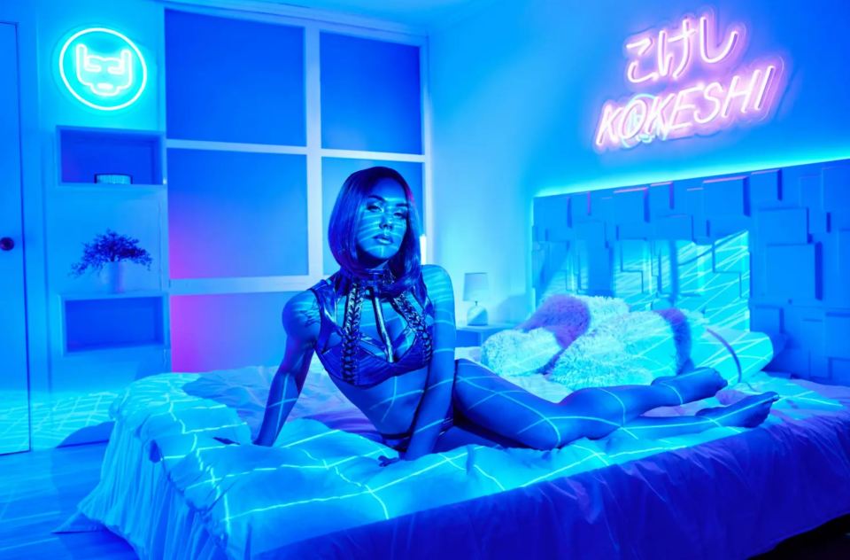 Illustration of a female robot sitting on a bed in a futuristic city.
