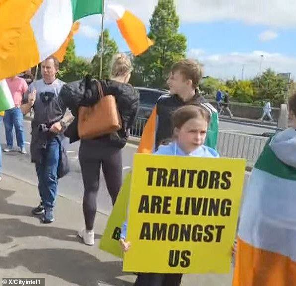 One little girl was seen holding a large sign that read: 'TRAITORS ARE LIVING AMONGST US'
