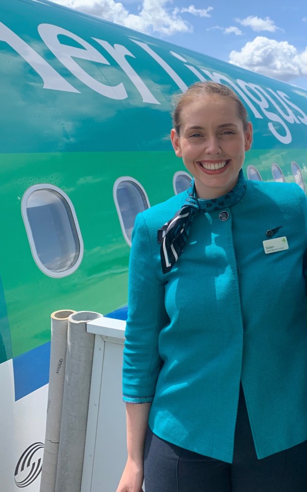 Aer Lingus flight attendant in uniform in front of an airplane.