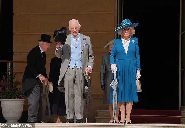 The monarch, 76, looked dapper in his grey and baby blue three-piece suit as he looked out over thousands of people who arrived for the event at Buckingham Palace on Wednesday afternoon