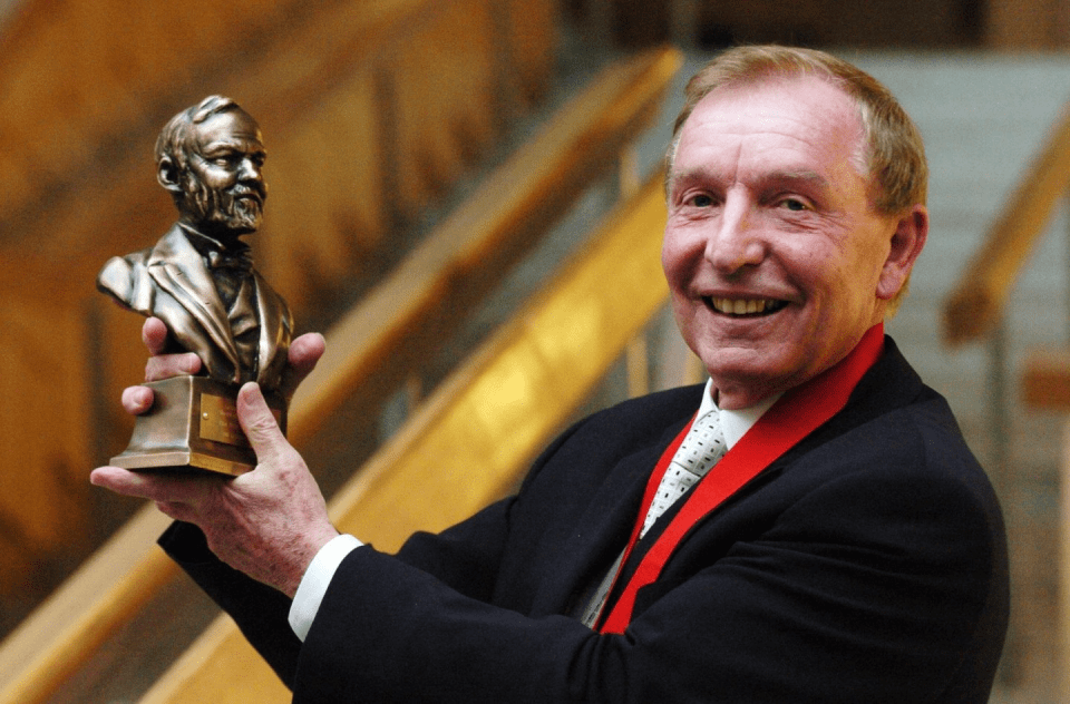 Man holding a bust award.