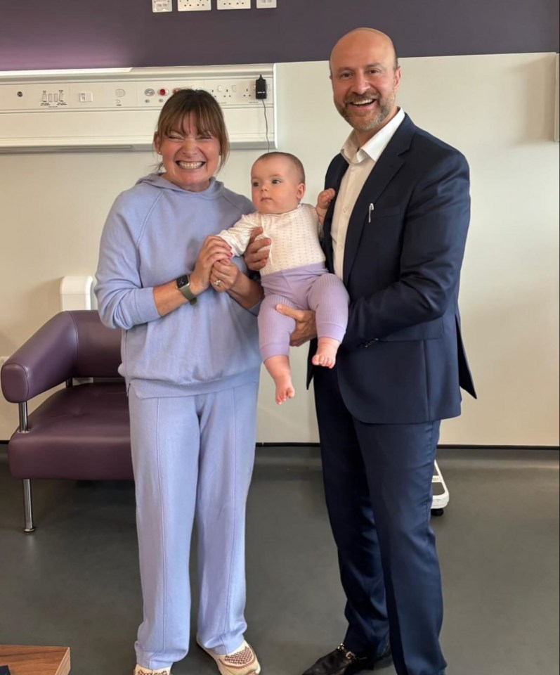Lorraine Kelly with a baby and a man in a suit.