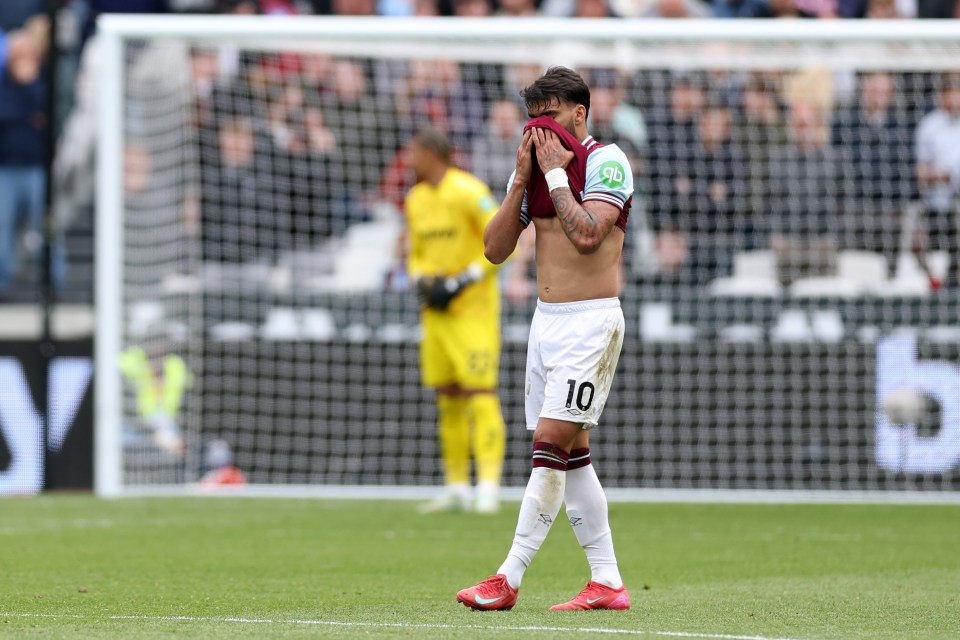 Lucas Paqueta of West Ham United on the field, head in hands.