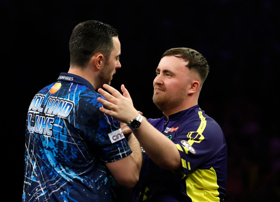 Luke Humphries and Luke Littler embracing after a darts match.