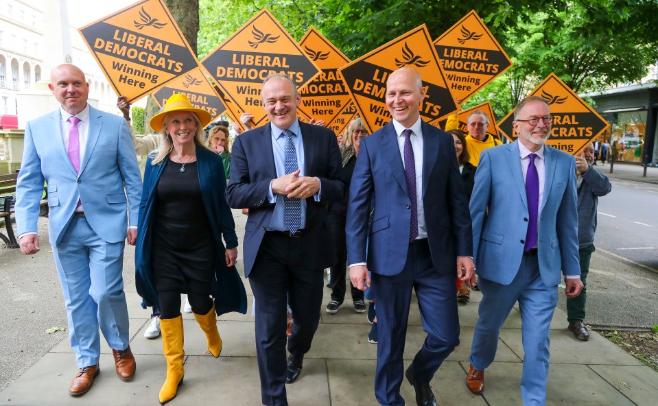 Ed Davey and other Liberal Democrat candidates and supporters walking while campaigning.