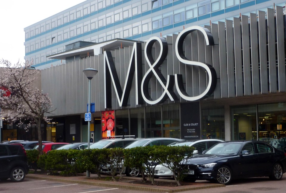 M&S store exterior with cars in the parking lot.