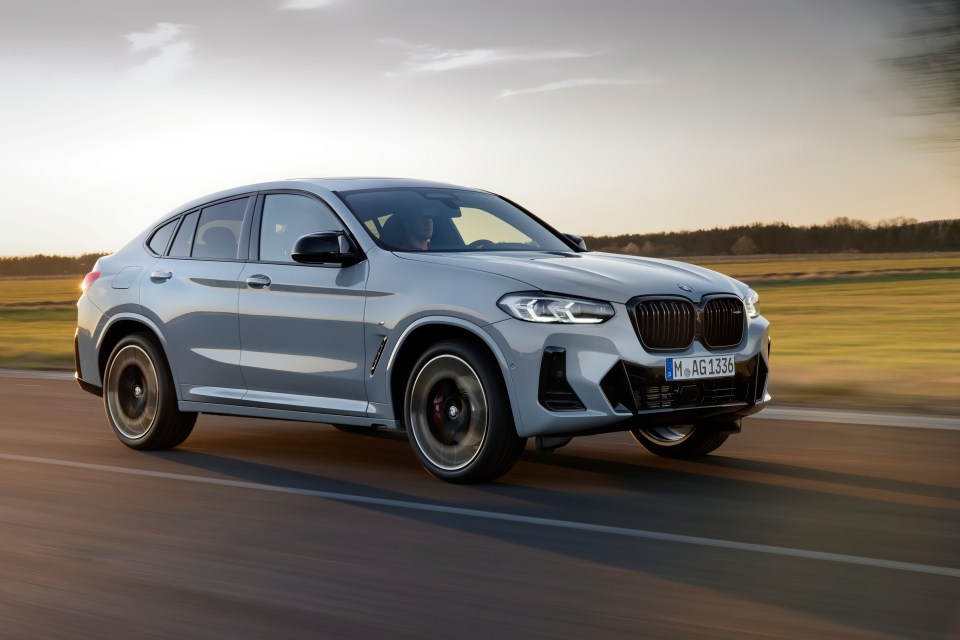 Silver BMW XM driving on a road.