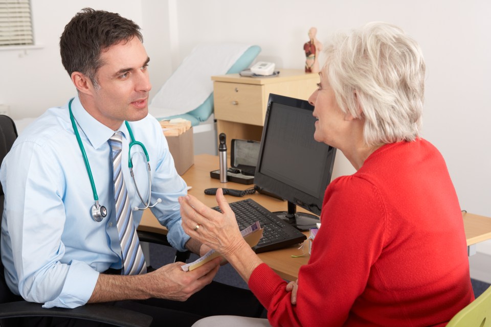 A doctor talking to a senior woman in his office.