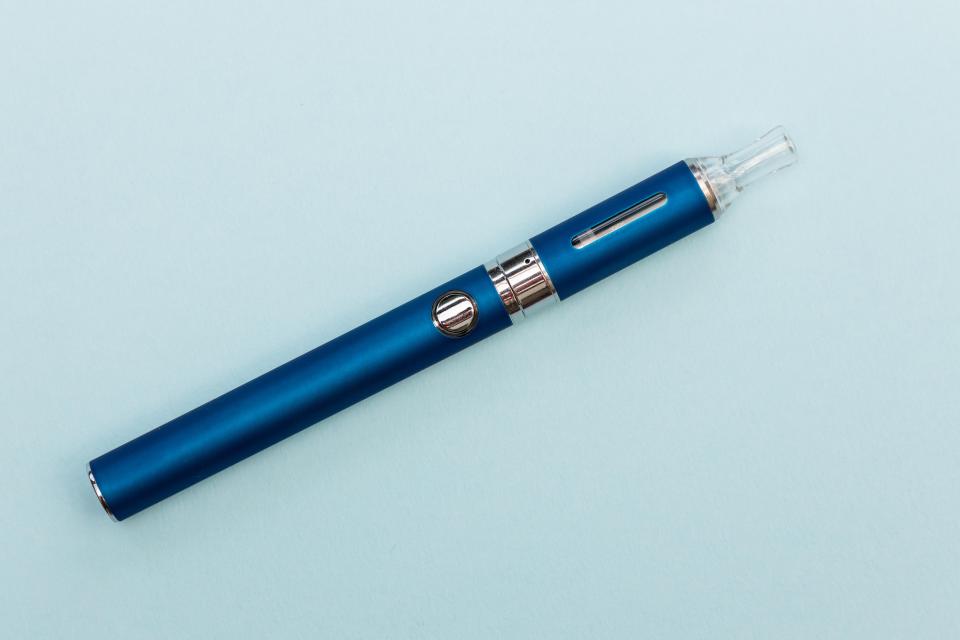 Blue electronic cigarette on a light blue background.